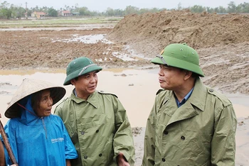 Bộ trưởng Nguyễn Xuân Cường trao đổi với Chủ tịch UBND tỉnh Quảng Trị Võ Văn Hưng và người dân về việc cải tạo đồng ruộng huyện Triệu Phong sau lũ.