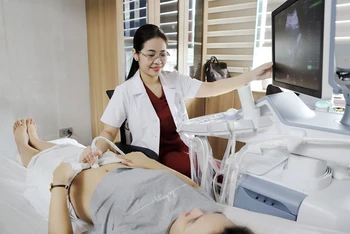 TS, BS Đinh Thúy Linh, Phó giám đốc Trung tâm Sàng lọc, chẩn đoán trước sinh và sơ sinh thăm khám cho thai phụ