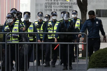 Cảnh sát Hàn Quốc đeo khẩu trang và tấm chắn nhựa trong lúc làm nhiệm vụ tại thủ đô Seoul, ngày 3-10. (Ảnh: AP)