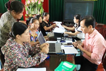 Cán bộ Ngân hàng Chính sách xã hội TP Hà Nội giúp người dân làm thủ tục vay vốn.