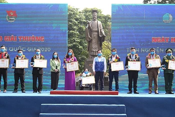Đồng chí Nguyễn Anh Tuấn (áo xanh, đứng giữa trong ảnh) trao Bằng khen tặng các tình nguyện viên có cống hiến xuất sắc trong năm vừa qua.