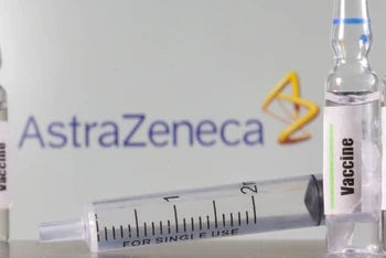 Một ống nghiệm dán nhãn vaccine được nhìn thấy phía trước logo AstraZeneca được chụp vào ngày 9-9-2020. Ảnh: Reuters.