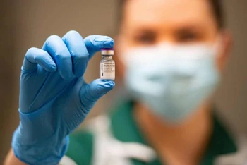 Một y tá cầm lọ vaccine Covis-19 của Pfizer và BioNTech. Ảnh: Reuters