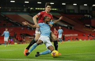 Sterling (áo xanh, Man City) tranh bóng với đội trưởng Man United H. Maguire.