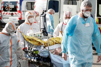 Các nhân viên y tế đang vận chuyển một bệnh nhân Covid-19 tại Lorient, Pháp. Ảnh: Reuters