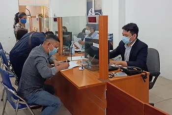 Người lao động làm thủ tục nhận trợ cấp thất nghiệp tại Trung tâm Dịch vụ việc làm Hà Nội. Ảnh: XUÂN CƯỜNG