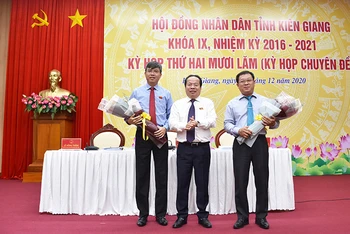 Ông Nguyễn Lưu Trung (trái) nhận hoa chúc mừng của Thường trực HĐND tỉnh Kiên Giang.