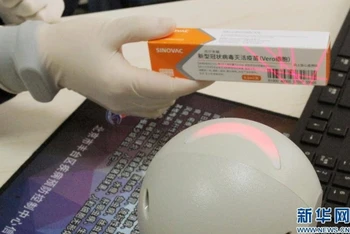 Nhân viên y tế quét mã vạch hộp vaccine phòng, chống Covid-19, chuẩn bị tiêm chủng. (Ảnh: Tân Hoa xã)