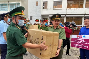 Đại tá Đinh Văn Nơi (trái) trao tặng khẩu trang y tế cho các chiến sĩ tham gia phòng, chống dịch trên tuyến biên giới.
