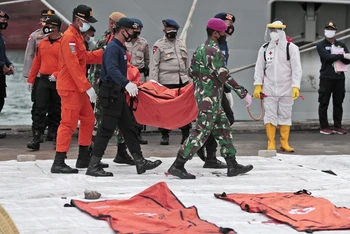 Lực lượng cứu nạn di chuyển túi chứa mảnh vỡ máy bay và phần thi thể người đến cảng Tanjung Priok. (Ảnh: AP)