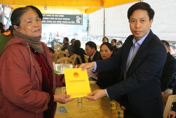 Phó Chủ tịch UBND tỉnh Thái Bình Lại Văn Hoàn (phải) trao số tiền 10 triệu đồng, hỗ trợ gia đình có nạn nhân thiệt mạng do hỏa hoạn.