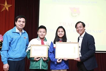 Đồng chí Nguyễn Bình Minh, Trưởng Ban Tổ chức Cuộc thi (ngoài cùng bên phải) trao giải nhất tặng nhóm tác giả Lương Thanh Thảo - Lương Đức Hiếu.