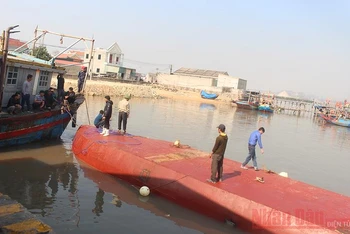 Tàu bị lật úp tại cảng cá Lạch Cờn, phường Quỳnh Phương, thị xã Hoàng Mai.