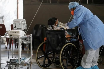 Nhân viên y tế chăm sóc bệnh nhân tại một khu dã chiến được thiết lập trong thời gian bùng phát dịch Covid-19 ở Pretoria, Nam Phi ngày 19-1. Ảnh: Reuters.