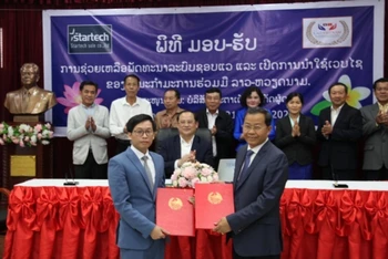 Thứ trưởng Kế hoạch và Đầu tư, Phó Chủ tịch Thường trực Ủy ban Hợp tác Lào - Việt Nam Khamphoi Keokinnaly (phải) tại lễ trao biên bản tài trợ dự án.