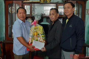 Phóng viên Báo Nhân Dân cùng đại diện Sở Lao động - Thương Binh và Xã hội tỉnh Kon Tum tặng quà Tết cho thương binh Trần Văn Thìn.