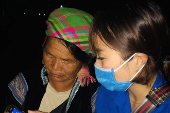 Tình nguyện viên hướng dẫn cài đặt ứng dụng Bluezone cho một người dân ở Lai Châu.