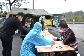 Cán bộ y tế thực hiện khai báo y tế đối với người ra vào địa bàn, ở chốt kiểm soát y tế Xuân Giao (Bảo Thắng - Lào Cai).