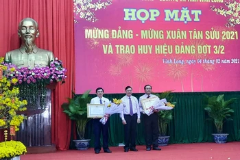 Bí thư Tỉnh ủy Vĩnh Long Trần Văn Rón thừa ủy quyền của Chủ tịch nước trao Huân chương Lao động hạng Nhì cho hai đồng chí ở Vĩnh Long.