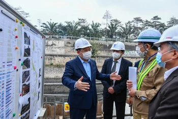 Đồng chí Vương Đình Huệ cùng các đồng chí lãnh đạo thành phố kiểm tra tại công trường xây dựng hệ thống cống bao cho sông Tô Lịch. (Ảnh: Duy Linh)