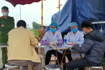 Thực hiện khai báo y tế tại chốt kiểm dịch cầu sông Hóa (tỉnh Thái Bình).