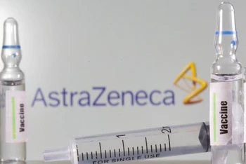 Lọ vaccine phía trước logo AstraZeneca. Ảnh: Reuters.