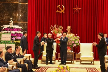 Bí thư Thành ủy Vương Đình Huệ tặng hoa chúc mừng Tổng Bí thư, Chủ tịch nước Nguyễn Phú Trọng. (Ảnh: DUY LINH)