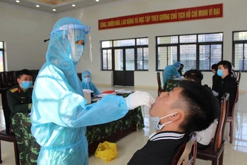 Lực lượng y tế lấy mẫu xét nghiệm Sars-CoV-2 cho các công dân ở TP Móng Cái chuẩn bị lên đường thực hiện nghĩa vụ quân sự. 