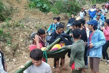 Người làng ở thôn Tre, xã Trà Tây gánh người bệnh ra đường lớn đón xe cấp cứu.