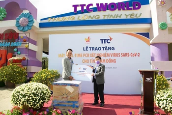 Chủ tịch Hội doanh nhân trẻ Việt Nam, Phó Chủ tịch Tập đoàn TTC Đặng Hồng Anh (trái) trao tặng hệ thống máy xét nghiệm tự động Real-time PCR đến đại diện tỉnh Lâm Đồng (phải).