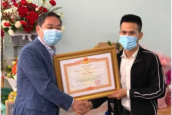 Phó Chủ tịch Thường trực UBND TP Hà Nội Lê Hồng Sơn trao tặng Bằng khen của Thủ tướng Chính phủ cho anh Nguyễn Ngọc Mạnh.