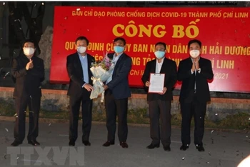 Lãnh đạo tỉnh Hải Dương trao quyết định của UBND tỉnh về gỡ bỏ phong tỏa TP Chí Linh. (Ảnh: TTXVN)