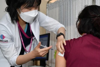 Một nhân viên y tế nhận được liều đầu tiên của vaccine ngừa Covid-19 của Pfizer - BioNTech tại trung tâm tiêm chủng của Trung tâm Y tế Quốc gia ở Seoul, Hàn Quốc ngày 27-2. Ảnh: Reuters.