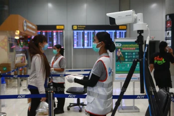 Nhân viên y tế đang kiểm tra nhiệt độ đối với hành khách tại sân bay Suvarnabhumi (Bangkok). (Ảnh: Bưu điện Bangkok)