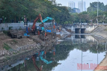 Thi công lắp đặt hệ thống cống thu gom nước xả thải dọc theo sông Tô Lịch. (Ảnh: ĐĂNG ANH)