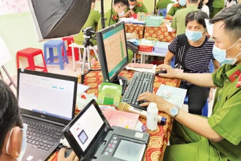 Cán bộ công an hỗ trợ người dân làm thẻ căn cước công dân có gắn chíp tại Nhà văn hóa liên phường Bình Trị Đông, quận Bình Tân.