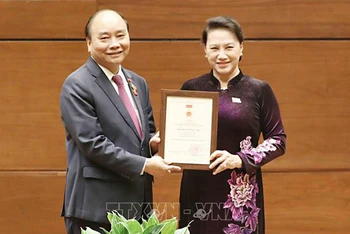 Chủ tịch QH Nguyễn Thị Kim Ngân trao Kỷ niệm chương Hoạt động Quốc hội tặng Thủ tướng Chính phủ Nguyễn Xuân Phúc. (Ảnh: TTXVN)