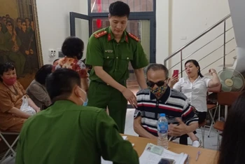 Đội Cảnh sát QLHC về TTXH Công an quận Ba Đình hỗ trợ ông Đinh Phương Thi là thương binh hỏng mắt, làm thủ tục cấp CCCD mới.