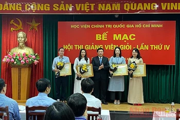 Đồng chí Nguyễn Xuân Thắng trao Bằng khen cho bốn giảng viên đạt danh hiệu Giảng viên xuất sắc. Ảnh: TRỊNH DŨNG