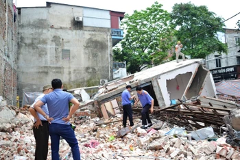 Lực lượng chức năng đang khám nghiệm hiện trường vụ đổ nhà số 117, đường Quy Hóa, phường Kim Tân, TP Lào Cai .