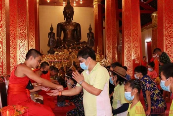 Theo quan niệm của người Lào, buộc chỉ cổ tay sẽ mang đến sức khỏe và may mắn.