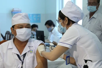 Điều dưỡng Nguyễn Văn Võ, Khoa kiểm soát nhiễm khuẩn thuộc đội phản ánh nhanh phòng, chống Covid-19 tại Bệnh viện đa khoa tỉnh Vĩnh Long được tiêm mũi đầu tiên.