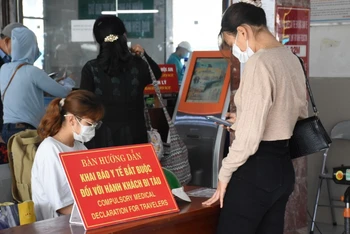 Nhân viên Ga Đà Nẵng hướng dẫn người dân khai báo y tế trước khi lên tàu.