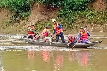 Lực lượng chức năng xã Hương Hóa (Quảng Bình) tìm kiếm thi thể nạn nhân bị lũ cuốn.