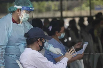 Nhân viên y tế đang hướng dẫn cho người dân đăng ký xét nghiệm tại quận Pathumwan, Thủ đô Bangkok, Thái Lan. (Ảnh: Bưu điện Bangkok)