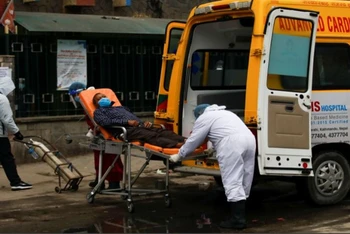 Nhân viên y tế đưa người bệnh Covid-19 tới bệnh viện. (Ảnh: Reuters)