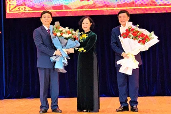 Đồng chí Trương Thị Mai tặng hoa chúc mừng đồng chí Nguyễn Đình Trung (bìa trái) và đồng chí Bùi Văn Cường (bìa phải).