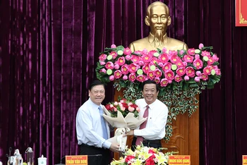 Phó Chủ nhiệm thường trực Ủy ban Kiểm tra Trung ương Trần Văn Rón tặng hoa chúc mừng tân Bí thư Tỉnh ủy Vĩnh Long Bùi Văn Nghiêm. 