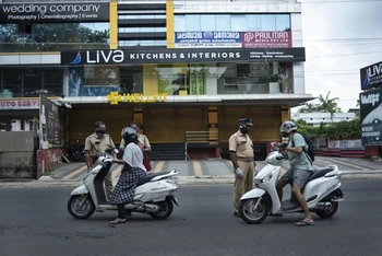 Cảnh sát kiểm tra giấy thông hành của người dân di chuyển tại bang Kerala trong thời gian bang này phong tỏa để kiểm soát dịch bệnh. (Ảnh: AP)