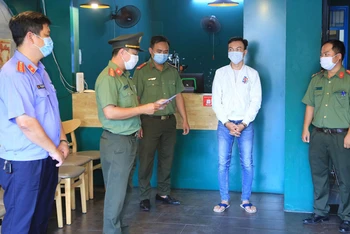 Lực lượng chức năng tống đạt quyết định khởi tố bị can, bắt tạm giam bốn tháng đối với Nguyễn Trần Anh Tuấn.